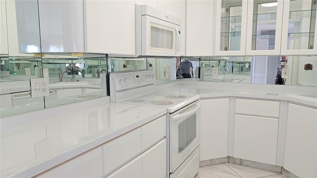 kitchen featuring backsplash, white cabinets, white appliances, and sink