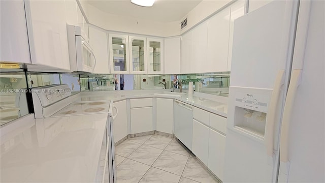 kitchen featuring washer / dryer, light stone countertops, white appliances, and white cabinetry