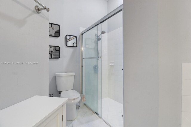 bathroom with walk in shower, tile patterned floors, toilet, and vanity