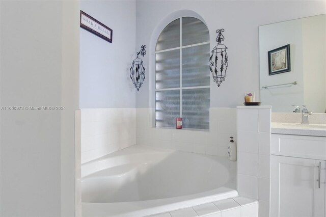 bathroom with vanity and a relaxing tiled tub