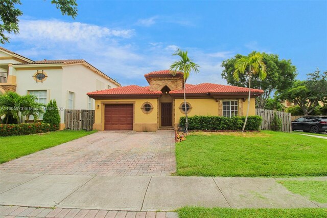 mediterranean / spanish house with a garage and a front yard