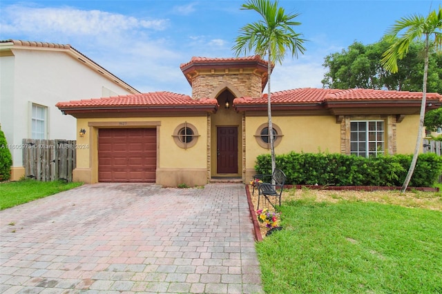 mediterranean / spanish home featuring a garage and a front lawn