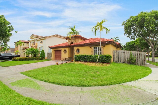 mediterranean / spanish-style home featuring a garage and a front lawn