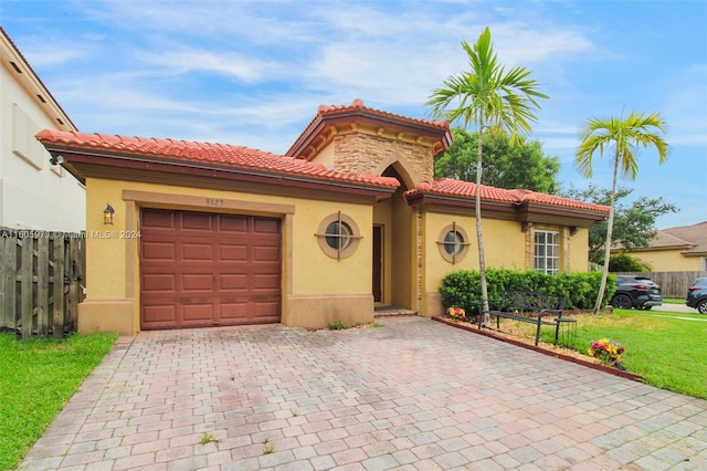 mediterranean / spanish house with a garage and a front lawn