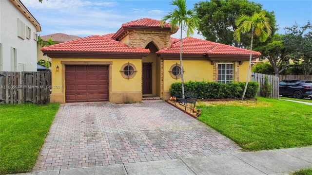 mediterranean / spanish-style home with a garage and a front yard