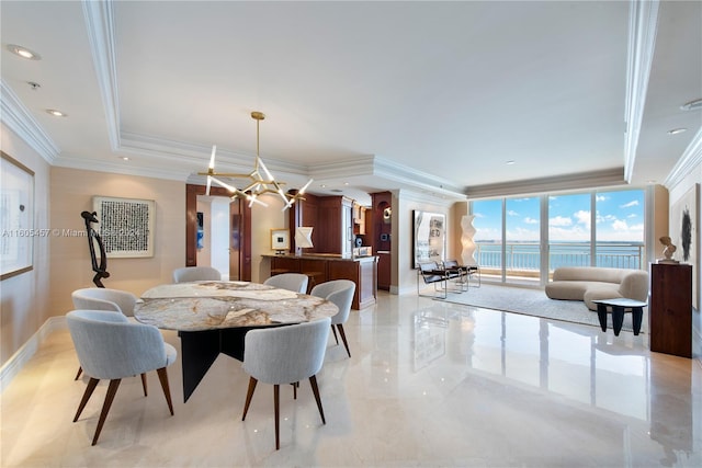 dining area featuring a chandelier, a water view, a raised ceiling, and ornamental molding