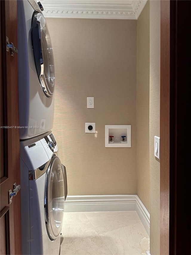 laundry area featuring stacked washer and clothes dryer and ornamental molding