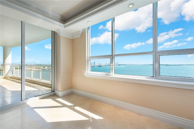 tiled spare room featuring a water view and crown molding