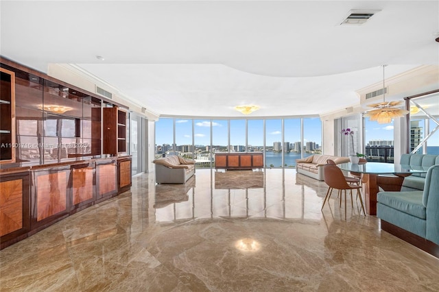 living room featuring floor to ceiling windows, a water view, and ornamental molding