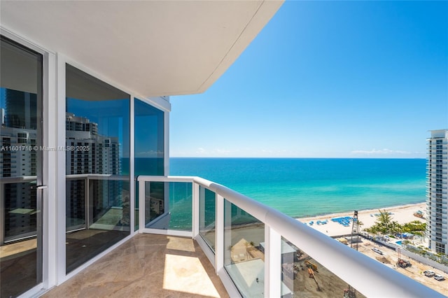 balcony with a water view and a beach view