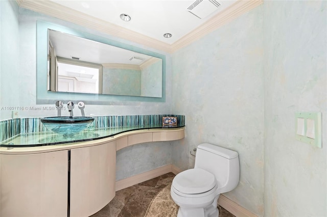 bathroom featuring baseboards, visible vents, a sink, ornamental molding, and toilet