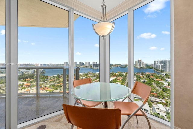 sunroom / solarium featuring a water view, plenty of natural light, and a city view