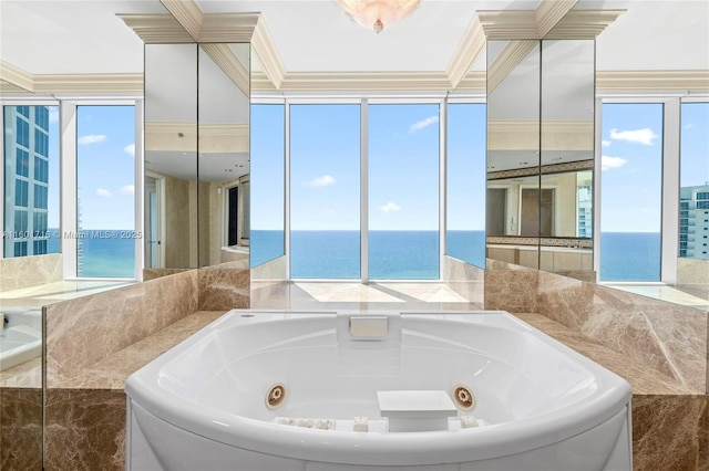 bathroom with crown molding, a tub with jets, and a water view