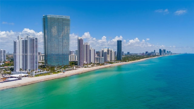 drone / aerial view with a city view, a beach view, and a water view