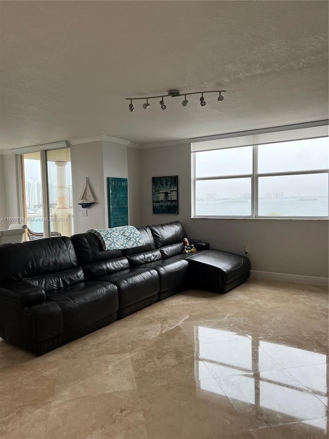 tiled living room featuring a textured ceiling, crown molding, and track lighting