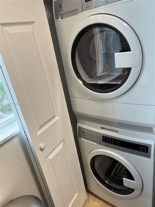 laundry room with stacked washing maching and dryer