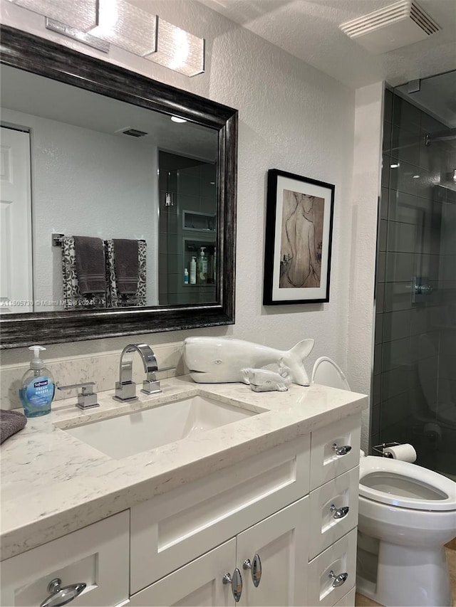 bathroom featuring a textured ceiling, toilet, and vanity