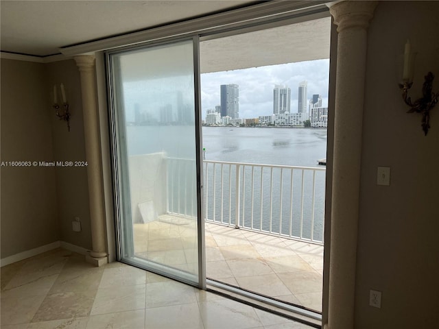 doorway featuring light tile patterned flooring and decorative columns