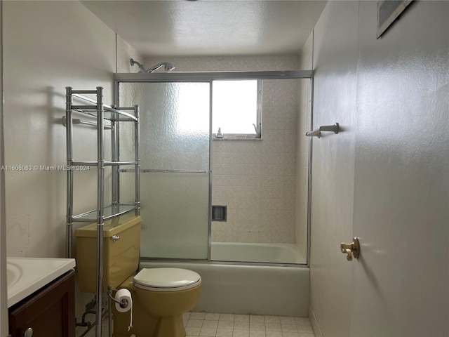 full bathroom featuring tile patterned flooring, toilet, enclosed tub / shower combo, and vanity