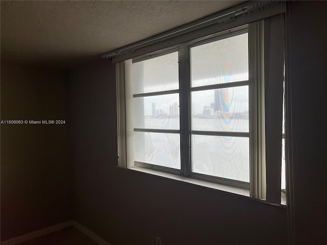 unfurnished room with a textured ceiling