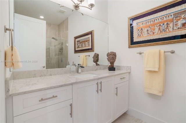 bathroom featuring a shower with door and vanity