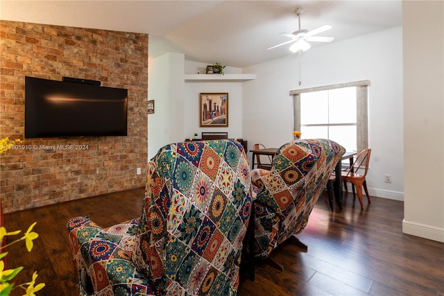 living room with ceiling fan, brick wall, dark hardwood / wood-style flooring, and vaulted ceiling