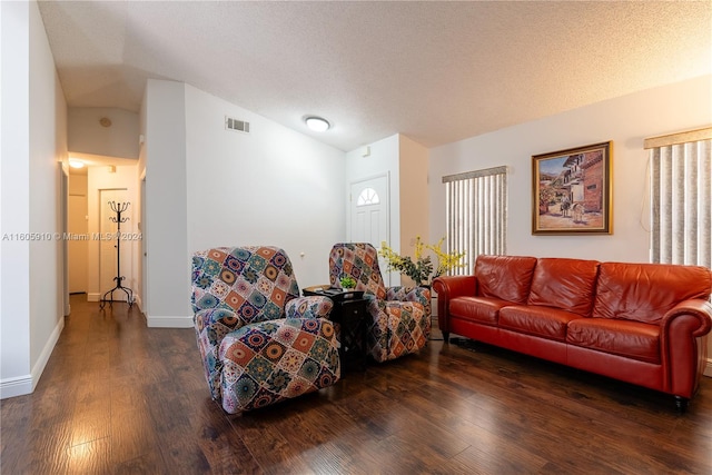 living room with a textured ceiling, hardwood / wood-style flooring, and lofted ceiling