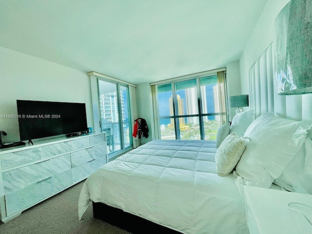 bedroom with carpet, a wall of windows, and access to outside