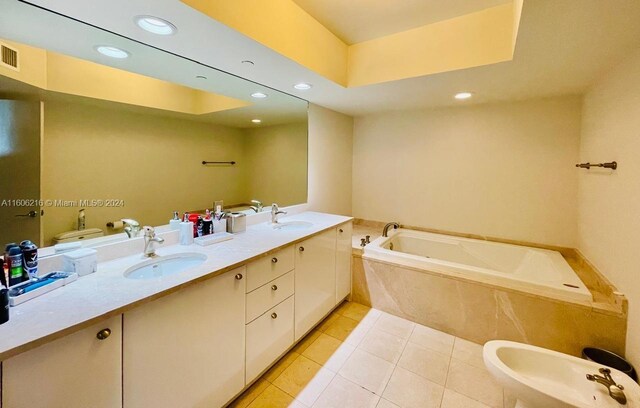 bathroom with toilet, vanity, tile patterned flooring, a bidet, and a relaxing tiled tub