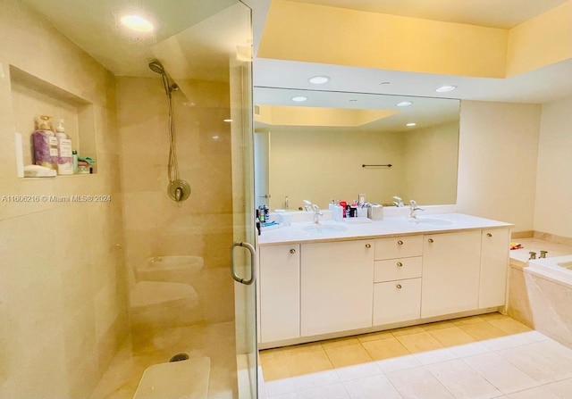 bathroom with tile patterned flooring, vanity, and shower with separate bathtub