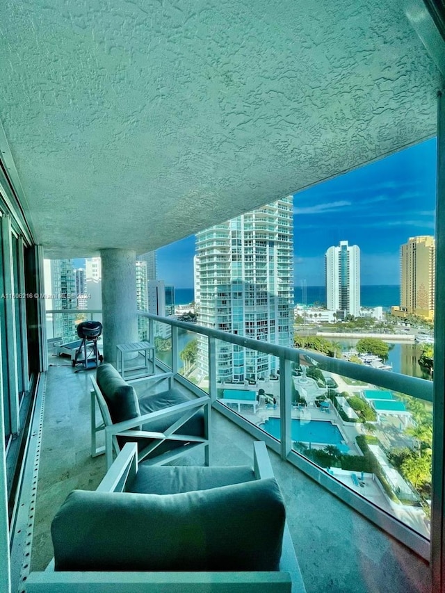 balcony at dusk with an outdoor living space and a water view