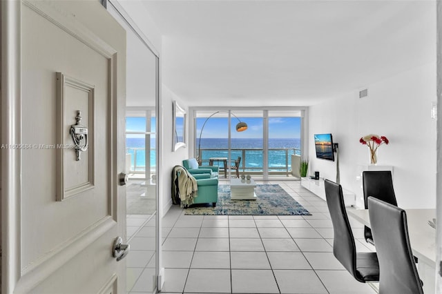 tiled living room featuring a wall of windows