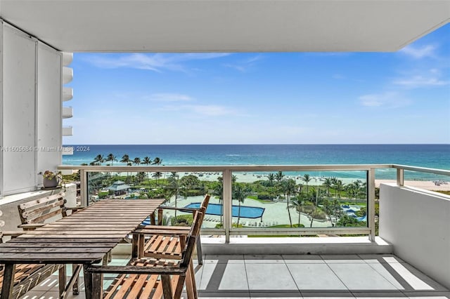 balcony featuring a beach view and a water view