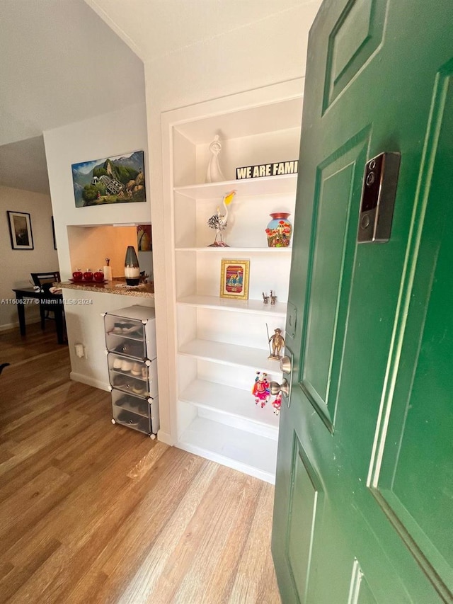 interior space featuring built in shelves and hardwood / wood-style floors