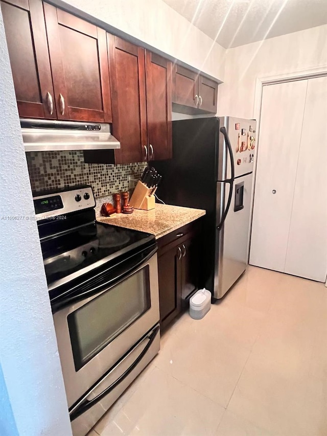 kitchen with light stone counters, light tile floors, backsplash, and appliances with stainless steel finishes