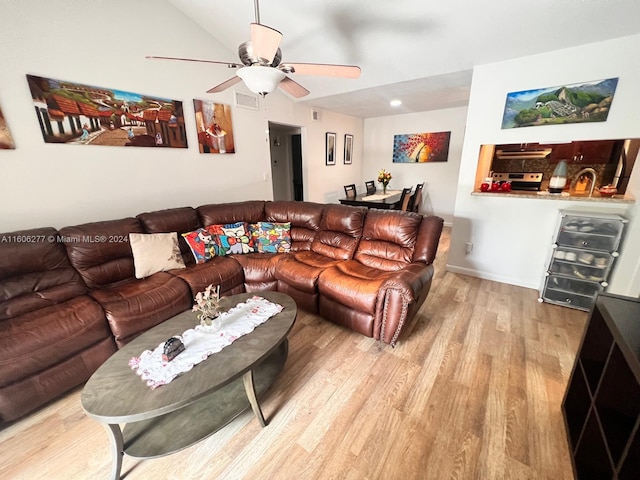 living room with ceiling fan, hardwood / wood-style floors, and lofted ceiling