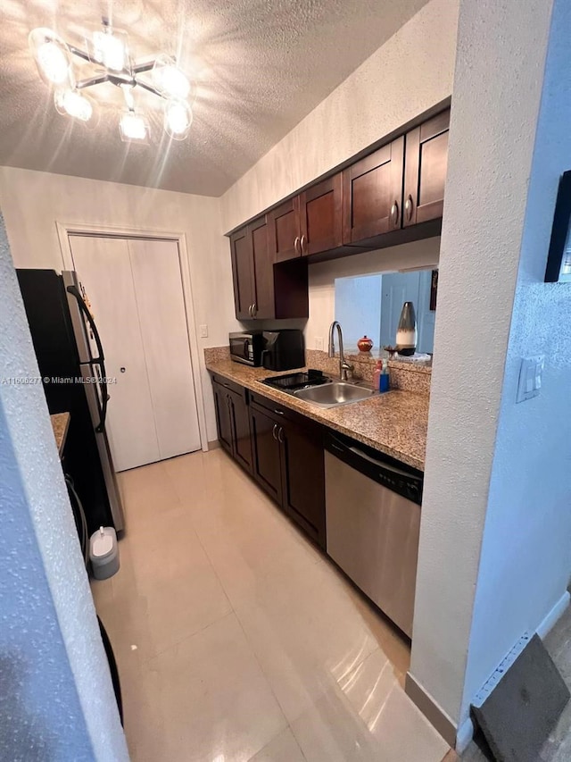 kitchen featuring a textured ceiling, stainless steel dishwasher, dark brown cabinetry, sink, and light tile floors