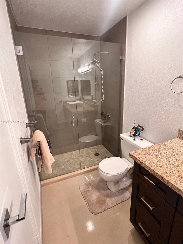 bathroom with toilet, tile flooring, an enclosed shower, vanity, and a textured ceiling