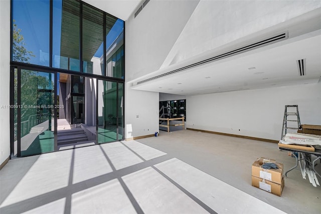 interior space with floor to ceiling windows and a towering ceiling