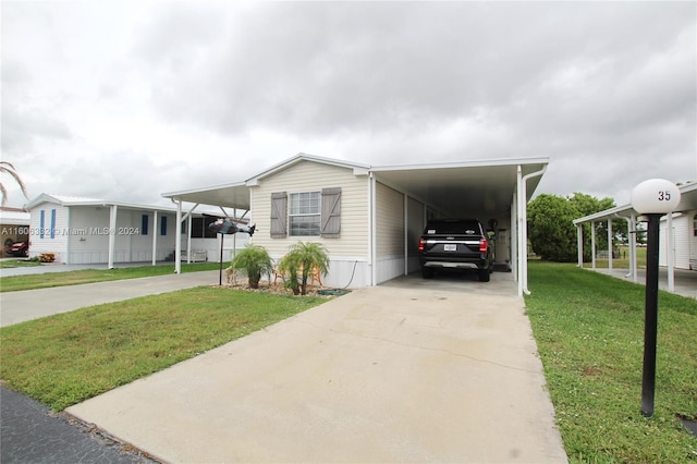 manufactured / mobile home with a front lawn and a carport