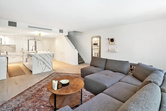 living room with sink and light hardwood / wood-style flooring