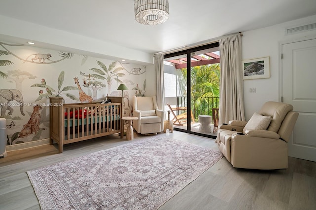 bedroom with light wood-type flooring, access to exterior, and a wall of windows