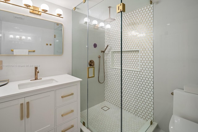 bathroom featuring toilet, a shower with door, and vanity