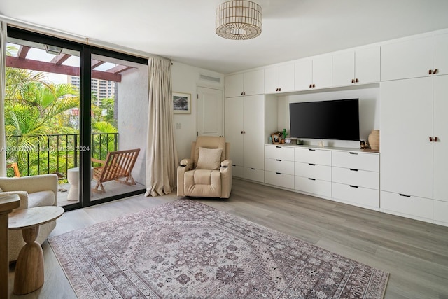 sitting room featuring a wall of windows and light hardwood / wood-style flooring