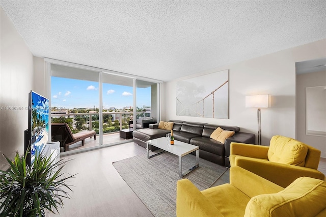 living room with floor to ceiling windows, a textured ceiling, and light hardwood / wood-style flooring