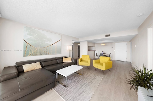 living room featuring a textured ceiling and light hardwood / wood-style flooring