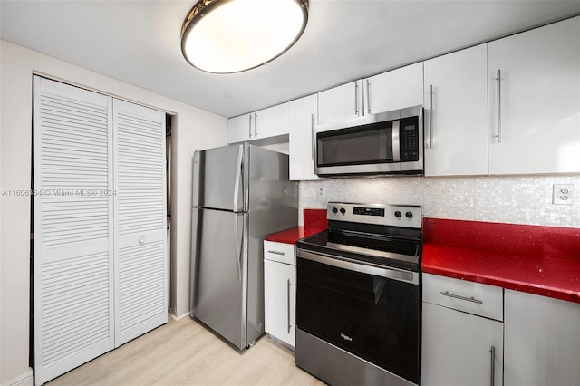 kitchen featuring white cabinets, decorative backsplash, light hardwood / wood-style floors, and stainless steel appliances