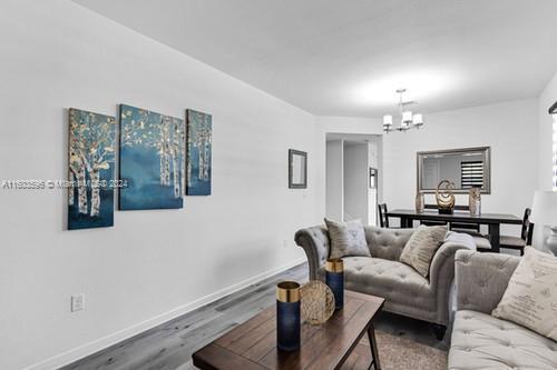 living room featuring an inviting chandelier and hardwood / wood-style flooring