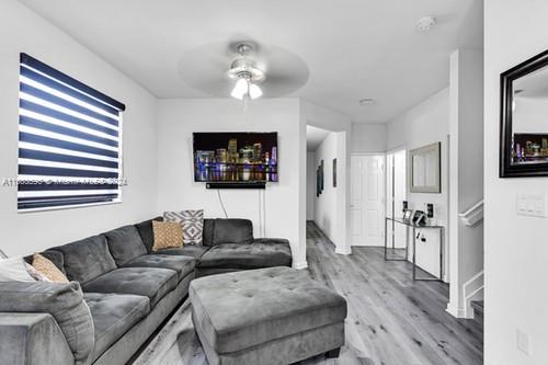 living room with ceiling fan and hardwood / wood-style floors