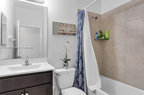 full bathroom featuring toilet, oversized vanity, and shower / bath combo with shower curtain